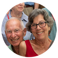 Photo of a man smiling broadly at the camera along side his wife.
