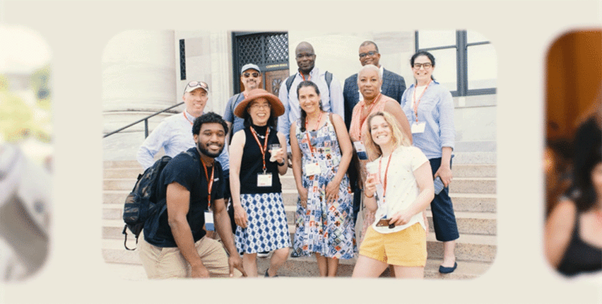 Group of alumni and student tour guides standing on marble steps.