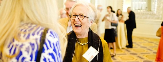 Reunion attendee smiling at other attendee.